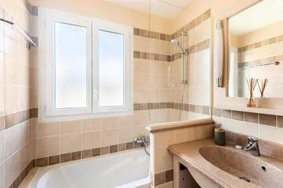a bathroom with a tub and a sink and a window at Les Coteaux de Pont Royal en Provence - maeva Home - Maison chaleureuse climatisée 4 pièces 6 personnes - Prestige - super Home MAE-2304 in Mallemort