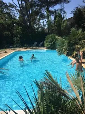 a group of people in a large blue swimming pool at Villa provençale et ses grands pins in Pernes-les-Fontaines