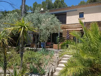 a garden in front of a house with plants at Villa provençale et ses grands pins in Pernes-les-Fontaines