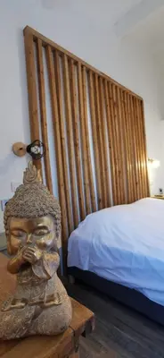 a statue of a head on a table next to a bed at La Petite Reine Du Ventoux in Sault-de-Vaucluse