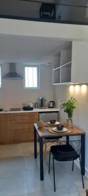 a kitchen with a table and a chair in it at La Pifote in Villes-sur-Auzon