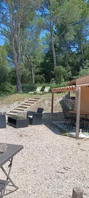 a patio with a picnic table and chairs and trees at La Pifote in Villes-sur-Auzon
