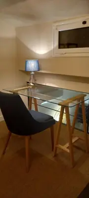 a glass table with a chair and a lamp on it at La Pifote in Villes-sur-Auzon