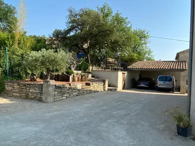 a house with a car parked in front of a driveway at Villa individuelle avec piscine privée proche du Ventoux in Blauvac