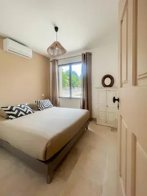 a bedroom with a large bed and a window at La Mirande à Lacoste in Lacoste