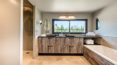 a bathroom with a sink and a tub and a window at Mas Sourso in Eygalières