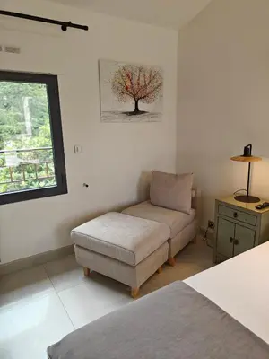 a room with a bed and a chair and a window at Mas Sourso in Eygalières