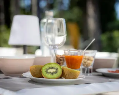 a plate of fruit and a glass of wine on a table at LES LODGES TAIZEN, séjour SPA- sans enfants in Saint-Cannat