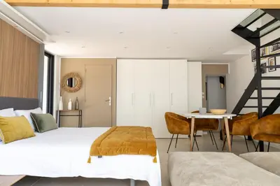 a bedroom with a bed and a table and chairs at LES LODGES TAIZEN, séjour SPA- sans enfants in Saint-Cannat