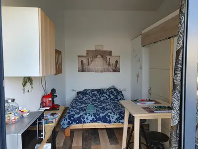 a small bedroom with a bed and a table at Pura vida in Mazan