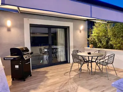 a patio with a grill and a table and chairs at Maison avec ses 2 terrasses et sa piscine in Eyragues