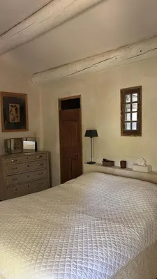 a bedroom with a bed and a dresser and a window at La Bastide des Chênes Lacoste in Lacoste