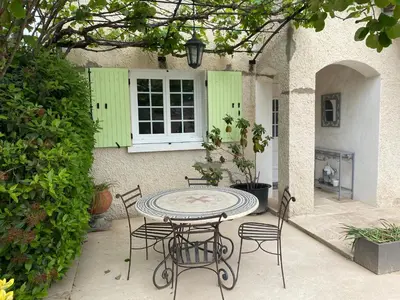 a patio with a table and chairs and a window at Beau Ciel in Châteauneuf-de-Gadagne
