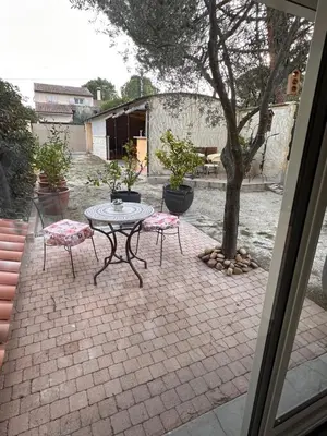 a patio with a table and two chairs and a tree at Beau Ciel in Châteauneuf-de-Gadagne
