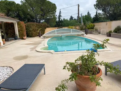 a swimming pool in a yard with two benches at Beau Ciel in Châteauneuf-de-Gadagne