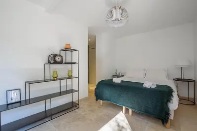 a bedroom with a bed with a green blanket at Mas Etienne Piscine&Nature Saint-Rémy Conciergerie in Saint-Rémy-de-Provence