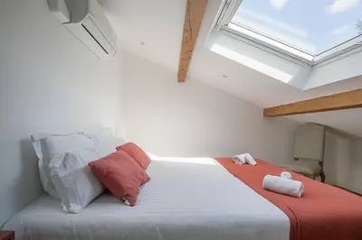 a bedroom with a large white bed with a skylight at Mas Etienne Piscine&Nature Saint-Rémy Conciergerie in Saint-Rémy-de-Provence