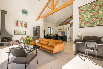 a living room with a couch and a piano at Mas Etienne Piscine&Nature Saint-Rémy Conciergerie in Saint-Rémy-de-Provence
