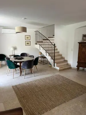 a living room with a table and chairs and a staircase at Villa Cocoon Lourmarin in Lourmarin