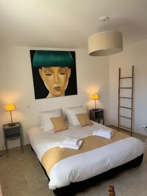 a large bed in a room with a painting on the wall at Villa Cocoon Lourmarin in Lourmarin
