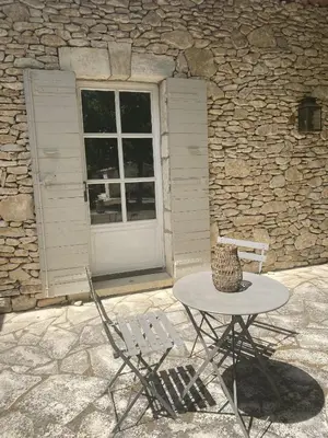 a table and two chairs in front of a building at La Bergerie Provencale - Luberon - Provence - villa with heated pool in Roussillon