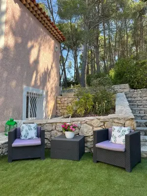 two chairs and a table in a yard at T2 avec jardin et piscine privée in Velaux