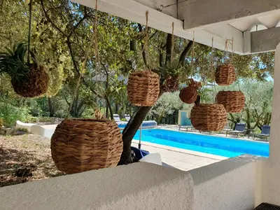 a group of baskets hanging over a swimming pool at Mas du Tilleul - LUBERON in Cadenet