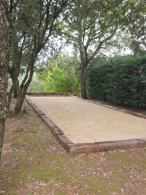 a large sandbox in the middle of a park with trees at Mas du Tilleul - LUBERON in Cadenet