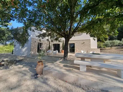 a table and a tree in front of a building at Mas du Tilleul - LUBERON in Cadenet