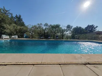 a swimming pool with blue water in a yard at Mas du Tilleul - LUBERON in Cadenet