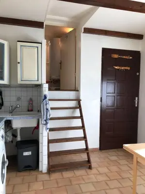 a kitchen with a stove top oven next to a washer at Studio Proche L'Isle sur Sorgue in Le Thor