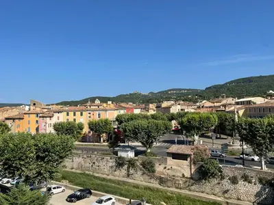 a city with cars parked in a parking lot at Appartement centre Apt Bèlavista luberon in Apt