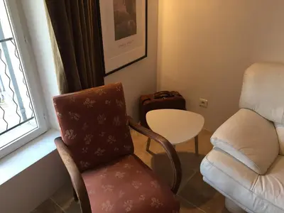 a living room with a chair and a table and a window at Appartement centre Apt Bèlavista luberon in Apt