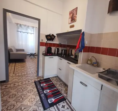 a kitchen with white cabinets and red and white tiles at Petit appart entier au cœur des REMPARTS - Netfix et connection fibre gratuits in Carpentras