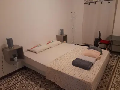 a bedroom with a large bed with two speakers at Petit appart entier au cœur des REMPARTS - Netfix et connection fibre gratuits in Carpentras
