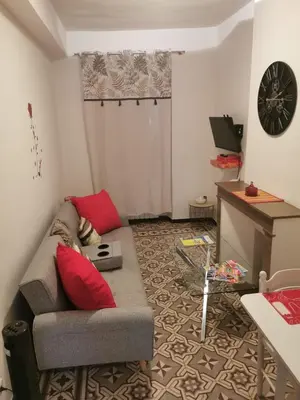 a living room with a couch and a tv at Petit appart entier au cœur des REMPARTS - Netfix et connection fibre gratuits in Carpentras