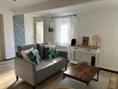 a living room with a couch and a table at Maisonnette rénovée en campagne in Velleron