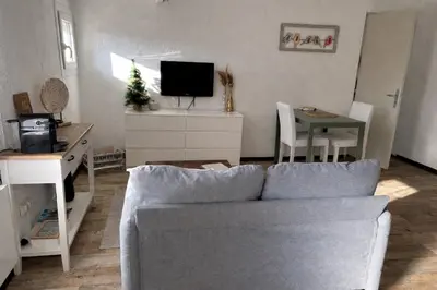 a living room with a couch and a table at Maisonnette rénovée en campagne in Velleron