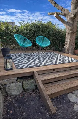 two blue chairs on a wooden deck with a tree at Maisonnette rénovée en campagne in Velleron