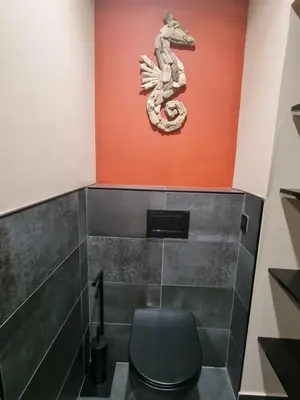 a bathroom with a statue of a dragon on the wall at Ma Charmante Maison En Provence in Lançon-Provence