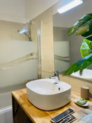 a bathroom with a white sink and a mirror at L’Écrin in Aix-en-Provence