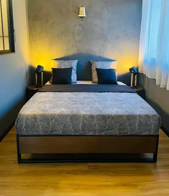 a bedroom with a bed with blue pillows at L’Écrin in Aix-en-Provence