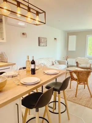a kitchen with a table with wine glasses on it at ''' Impasse d'un Instant ''' 8min Aix - Clim & Parking in Venelles