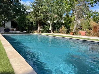 a swimming pool with blue water in a yard at Superbe bas de villaIX - Maison Odonata in Aix-en-Provence