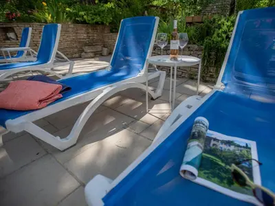 two blue chairs and a table with a bottle of wine at Le grand Liodrey in Céreste