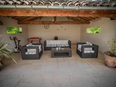 a patio with three couches and a table at Le grand Liodrey in Céreste