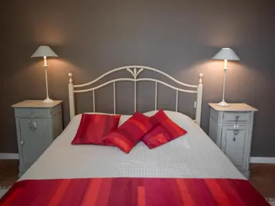 a bed with three red pillows and two night stands at Liodrey in Céreste