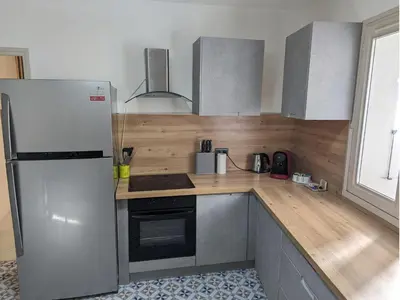 a kitchen with a white refrigerator and wooden counter top at Appartement Cosy centre ville in LʼIsle-sur-la-Sorgue