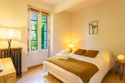 a bedroom with a bed and a window at Le Gîte du Carmel in Carpentras