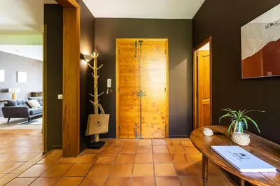 a living room with a wooden door and a table at Le Gîte du Carmel in Carpentras